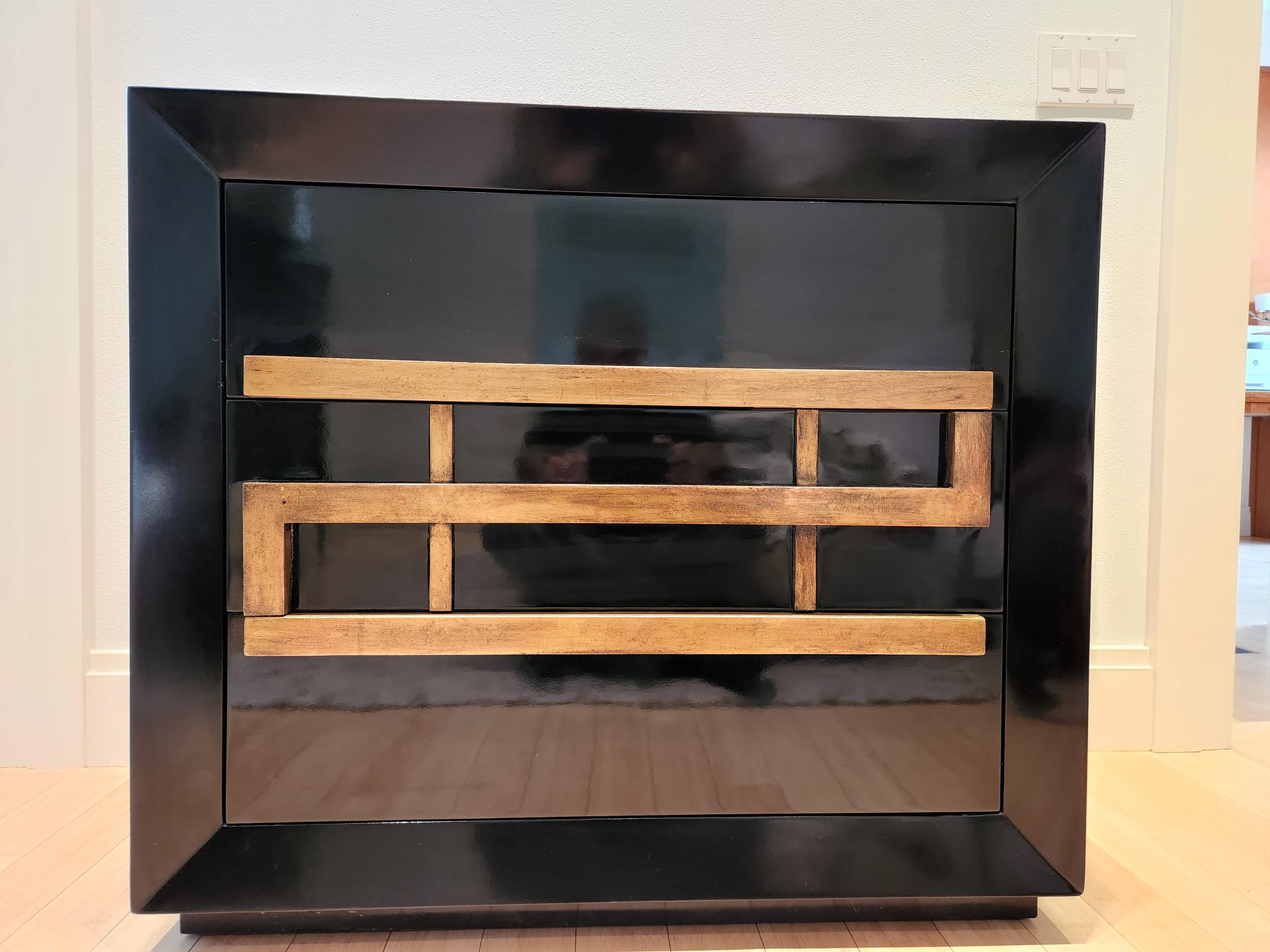 Black-lacquer chest refinished with gold trim